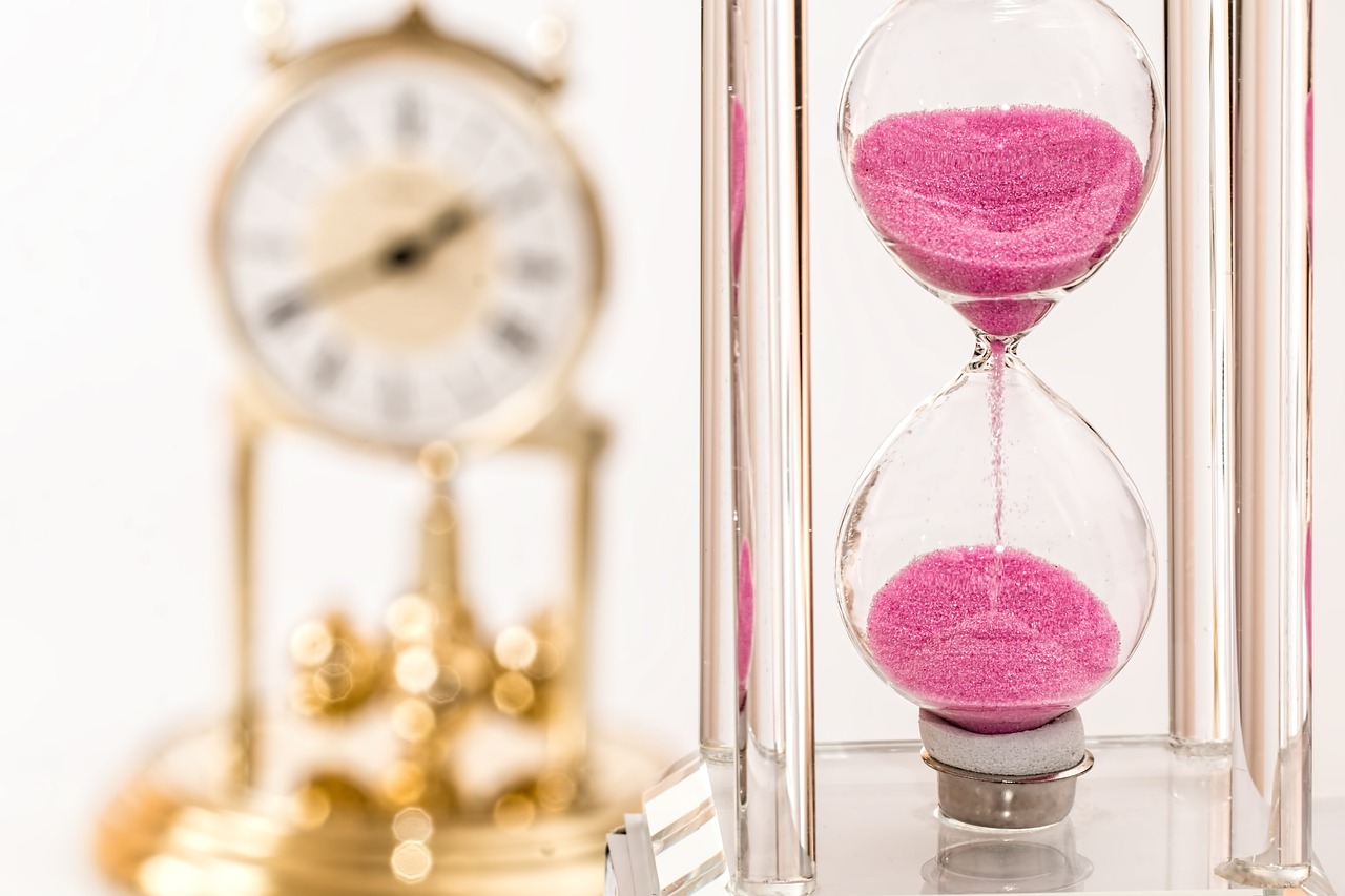 hourglass with pink sand.