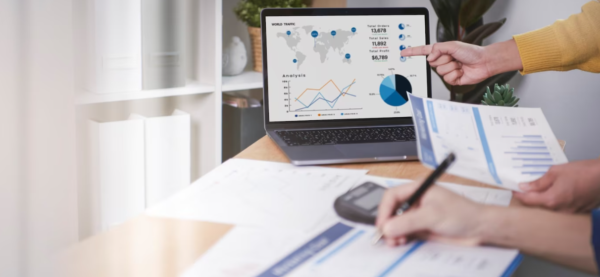 two people in the office, one shows the graphs on the screen